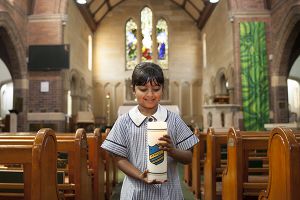 McAuley Catholic Primary School Rose Bay student carrying candle at church